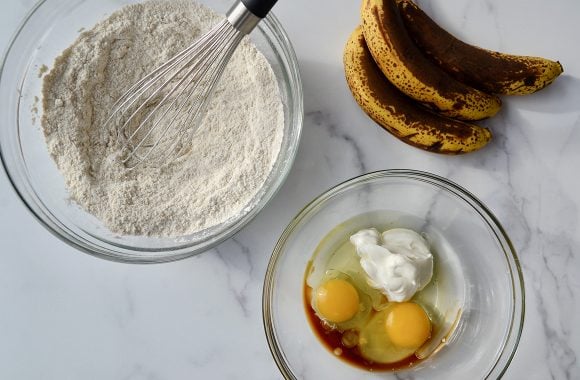 Glass bowls containing the ingredients to make Greek Yogurt Banana Bread