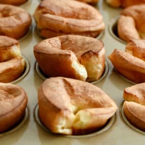 A closeup view of popovers in a muffin pan.