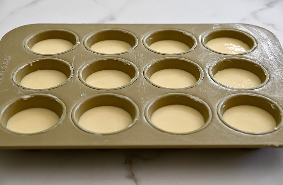 A muffin tin filled with popover batter.