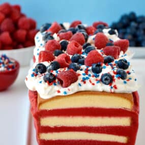 A frozen pound cake layered with raspberry sorbet topped with cool whip, fresh raspberries and blueberries, and patriotic sprinkles.