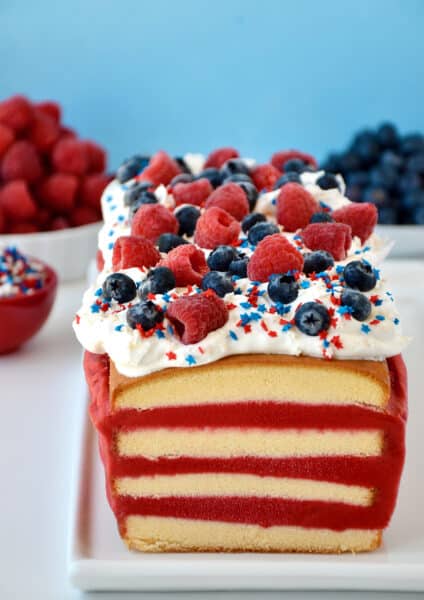 A frozen pound cake layered with raspberry sorbet topped with cool whip, fresh raspberries and blueberries, and patriotic sprinkles.