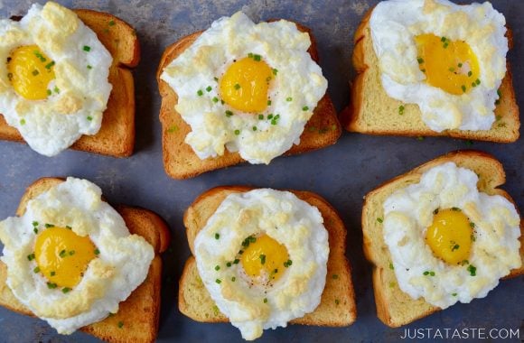 A silver baking sheet containing Cloud Eggs on top of brioche toast