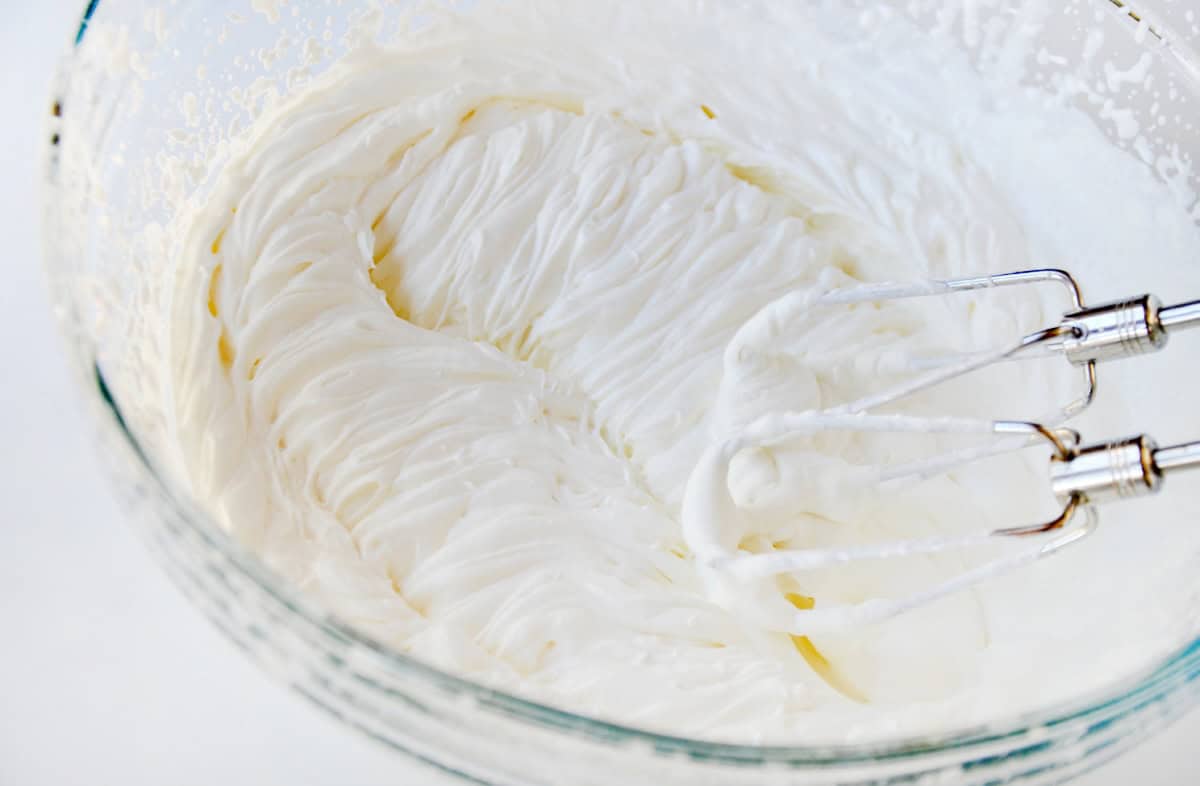 Whip cream to stiff peaks in a mixing bowl.