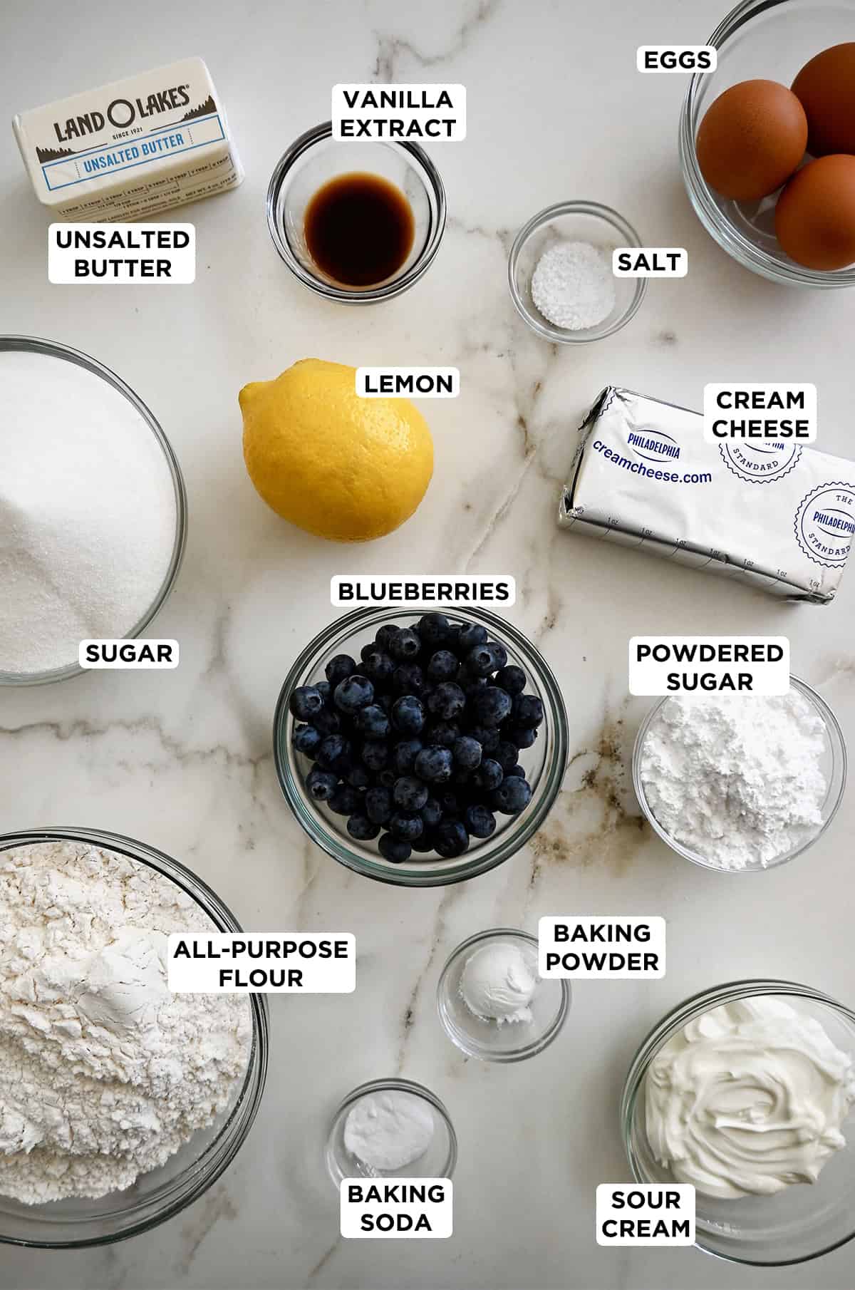 All of the ingredients needed to make a lemon blueberry pound cake with a lemon glaze.