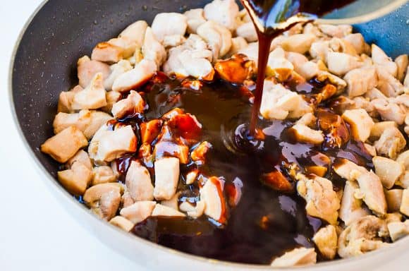 Diced chicken thighs with sauce being poured on top