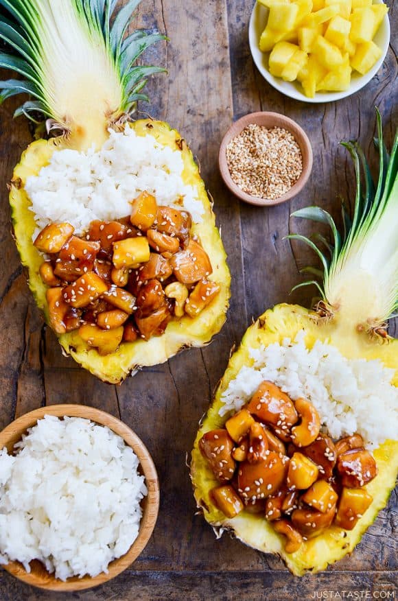 Two pineapple bowls filled with chicken and white rice