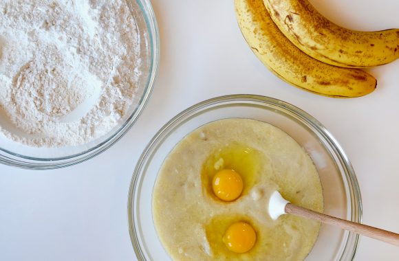 Two glass bowls filled with wet and dry ingredients for banana bread