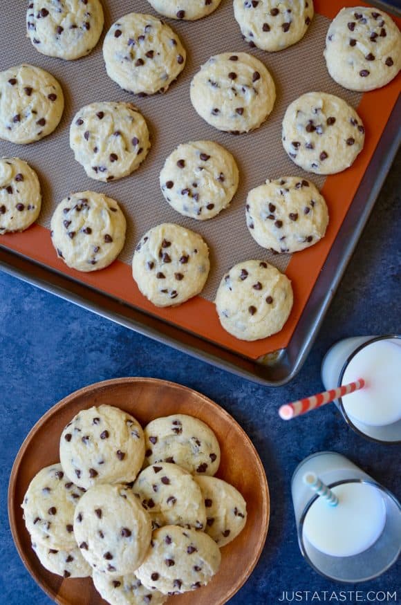 A baking sheet with Cake Mix Chocolate Chip Cookies and two glasses of milk