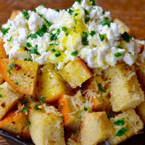 A skillet filled with cheesy garlic bread topped with ricotta cheese