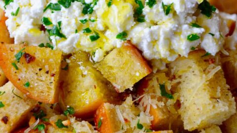 A skillet filled with cheesy garlic bread topped with ricotta cheese