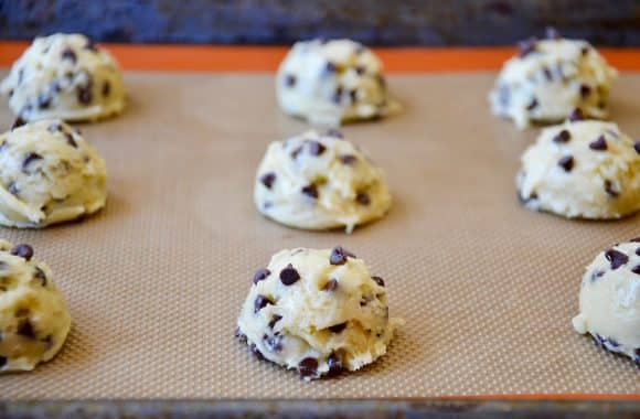 Raw cookie dough mounds on a baking sheet