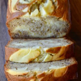 Cream cheese banana bread sliced and served on a cutting board