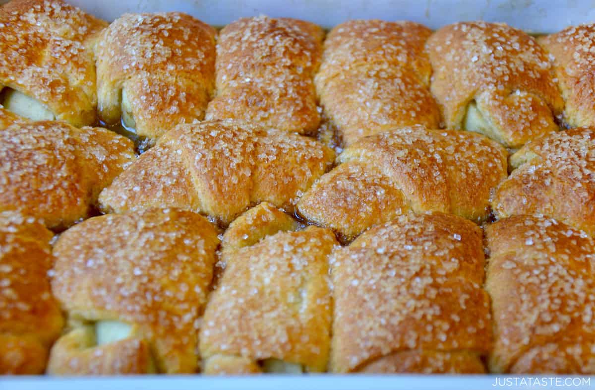 Golden brown crescent roll apple dumplings topped with sanding sugar.