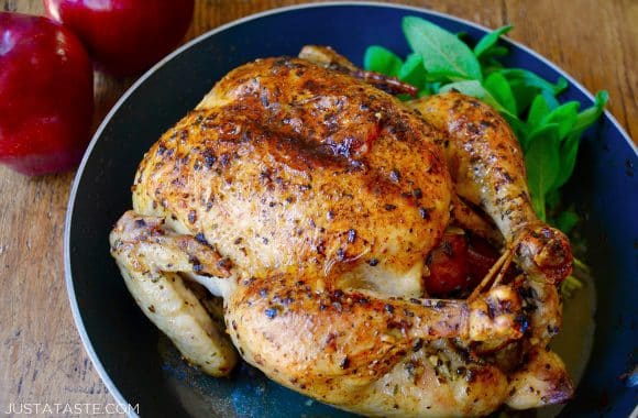 A roast chicken with apples and sage in a skillet