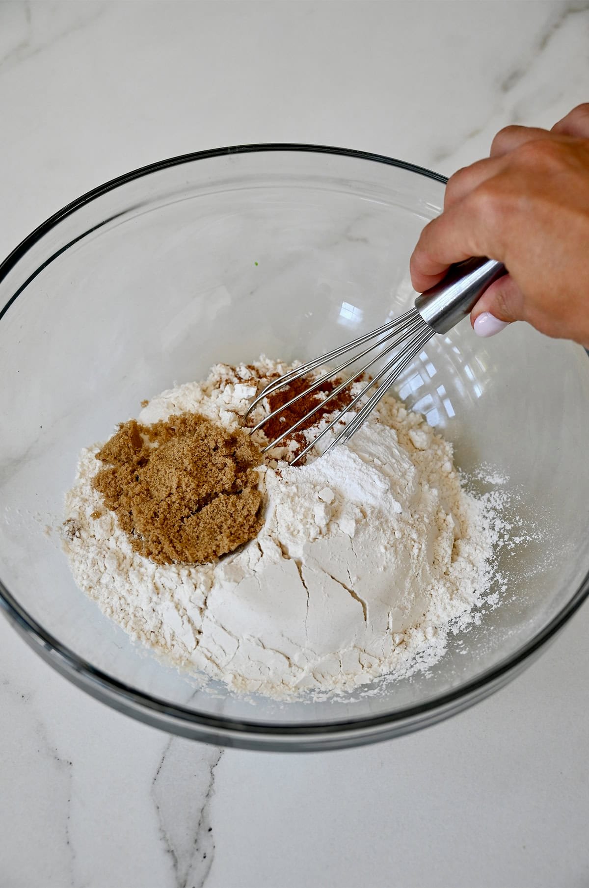 Whisking flour, cinnamon, brown sugar and baking powder together in a glass bowl.
