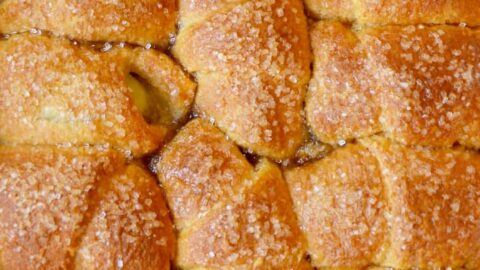 A pan of Crescent Roll Apple Dumplings studded with sanding sugar