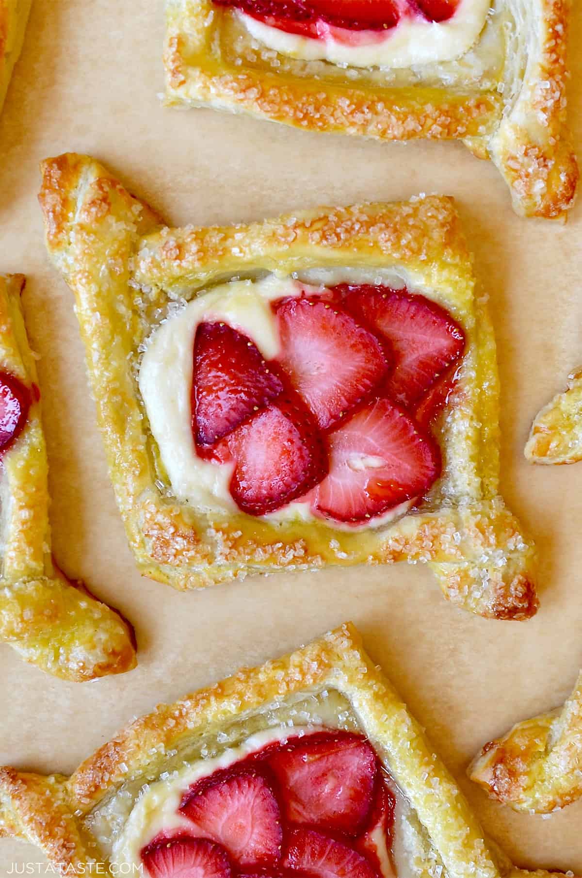 Cheese danish topped with fresh strawberries and sprinkled with sanding sugar.