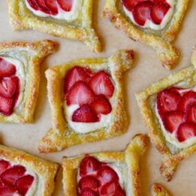 Cream cheese Danish pastries with strawberries on tan parchment paper