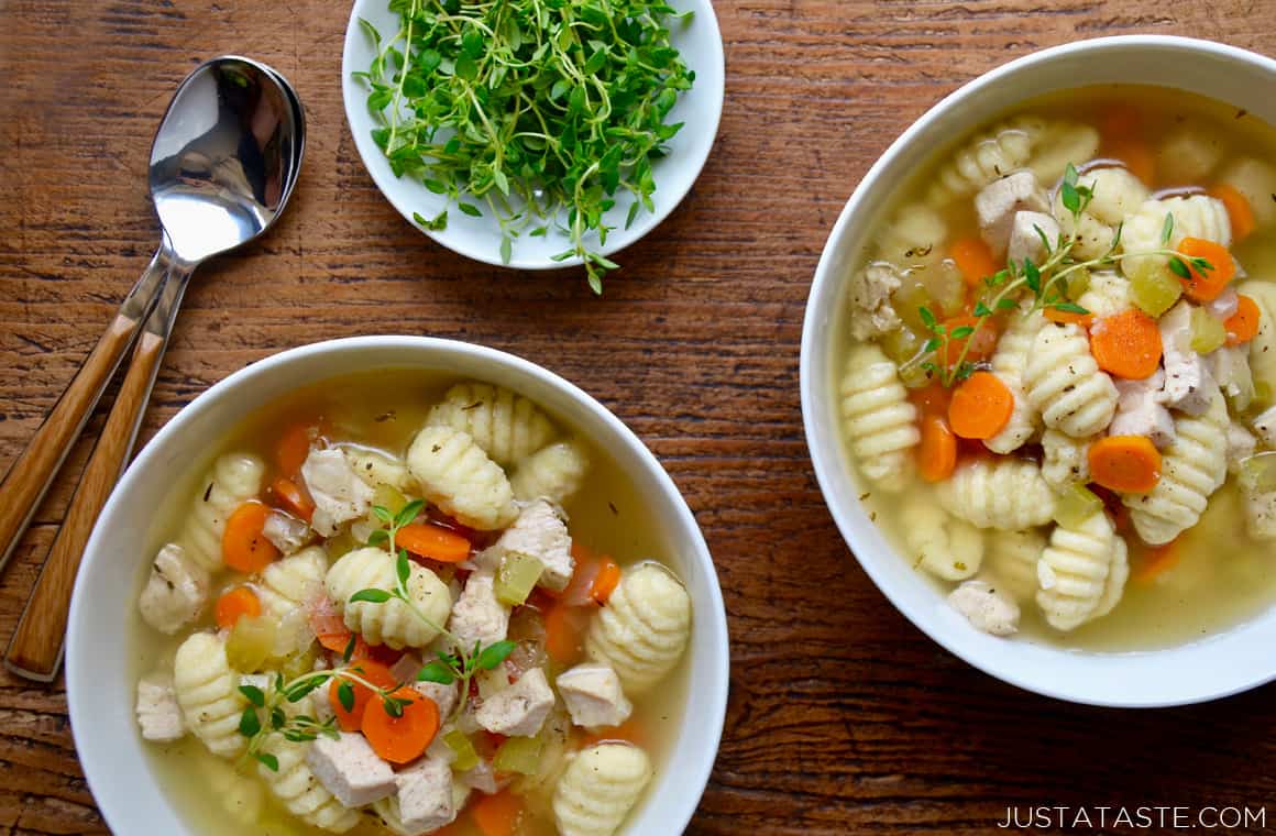 Two bowls of gnocchi chicken soup with fresh thyme