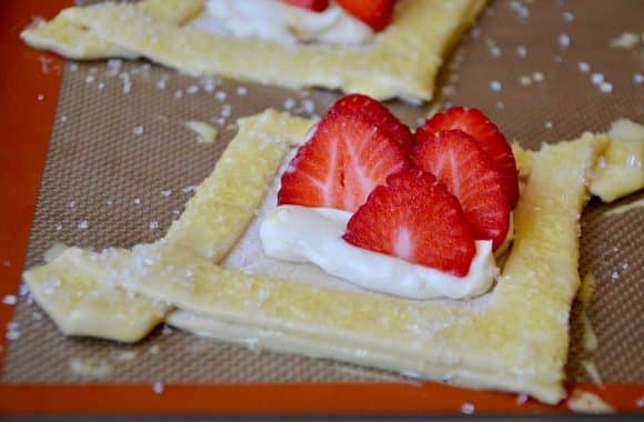 Cream cheese and strawberry filling inside a puff pastry Danish