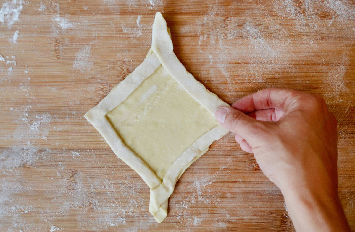 Diamond-shaped Danish puff pastry dough on a cutting board. 