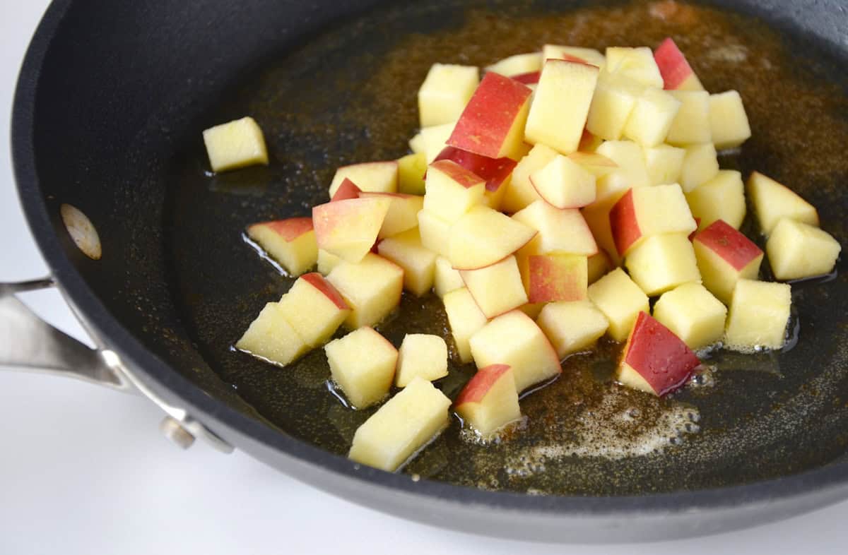 Chopped, sautéed apples with brown sugar in a pan.