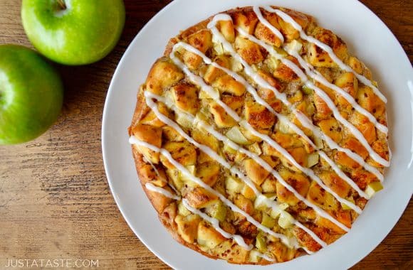 A white plate with Apple Cinnamon Roll Bake topped with icing