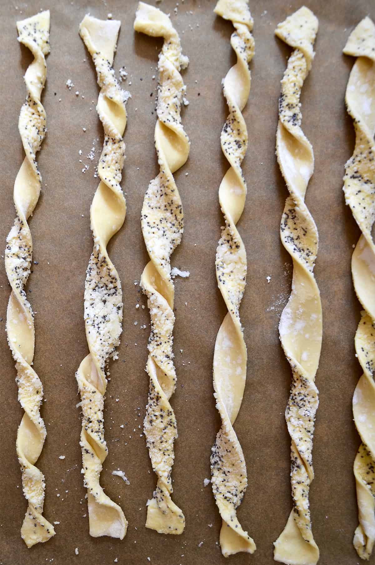 Twisted puff pastry strips on parchment paper.