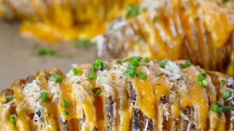 Hasselback potatoes will with cheese on a foil-lined baking sheet
