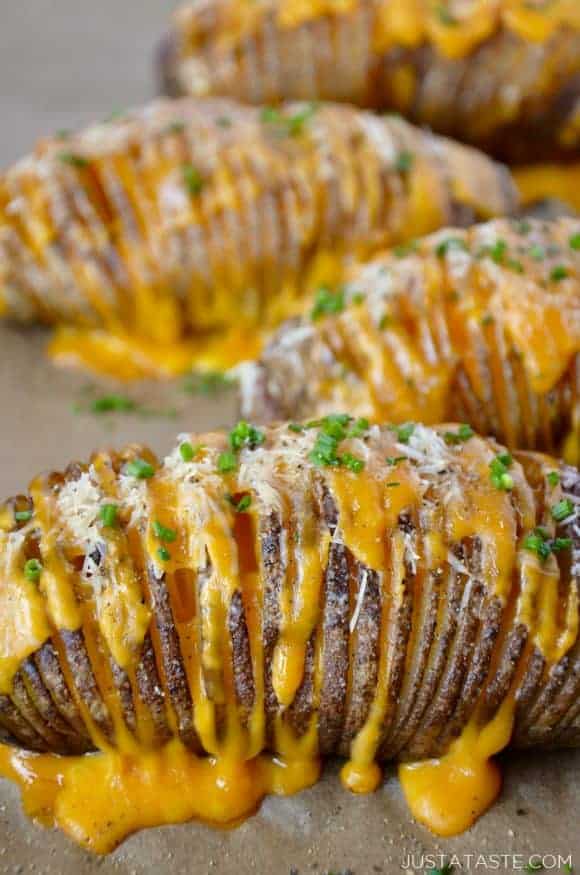 Hasselback potatoes filled with cheese on a baking sheet