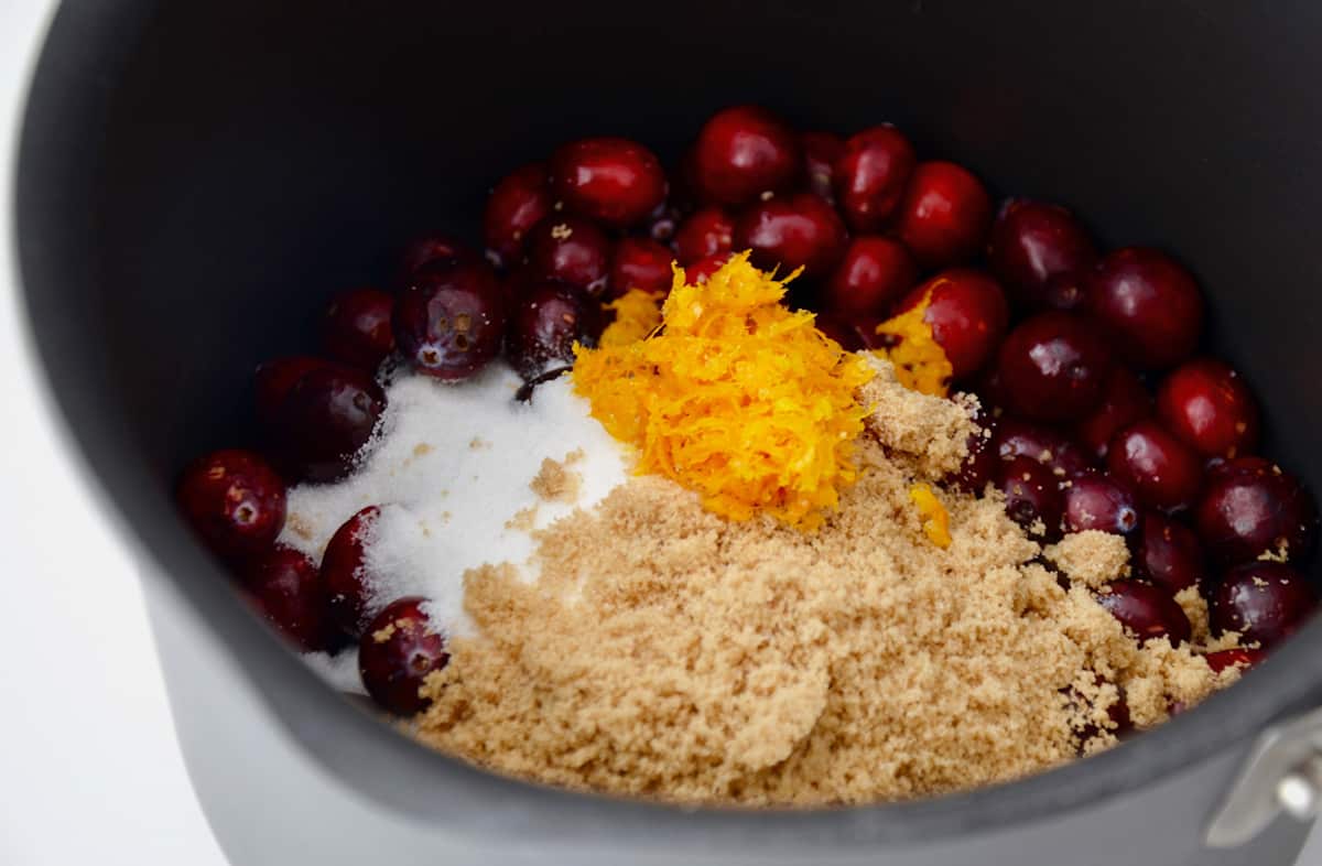 Cranberries, white and brown sugars, orange juice, and orange zest in a saucepan.