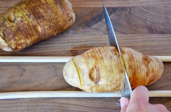 Cutting hasselback potatoes on a cutting board