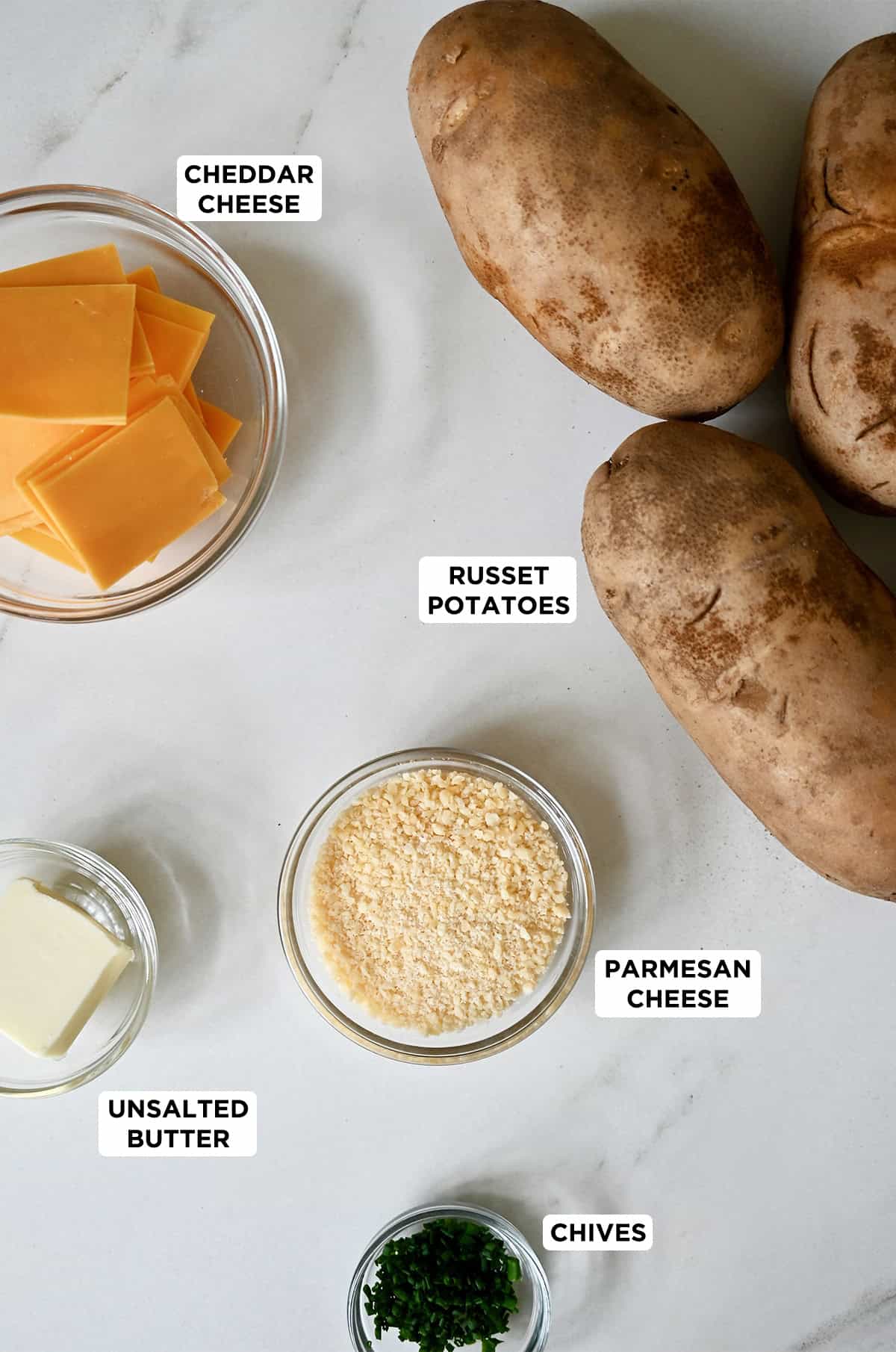 Ingredients to make hasselback potatoes with cheddar cheese and Parmesan.