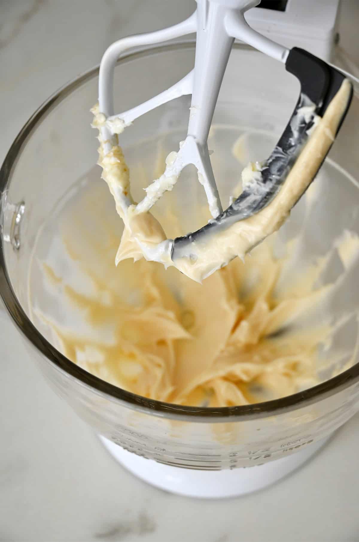 Creamed butter and powdered sugar in a bowl of a stand mixer fitted with the paddle attachment.