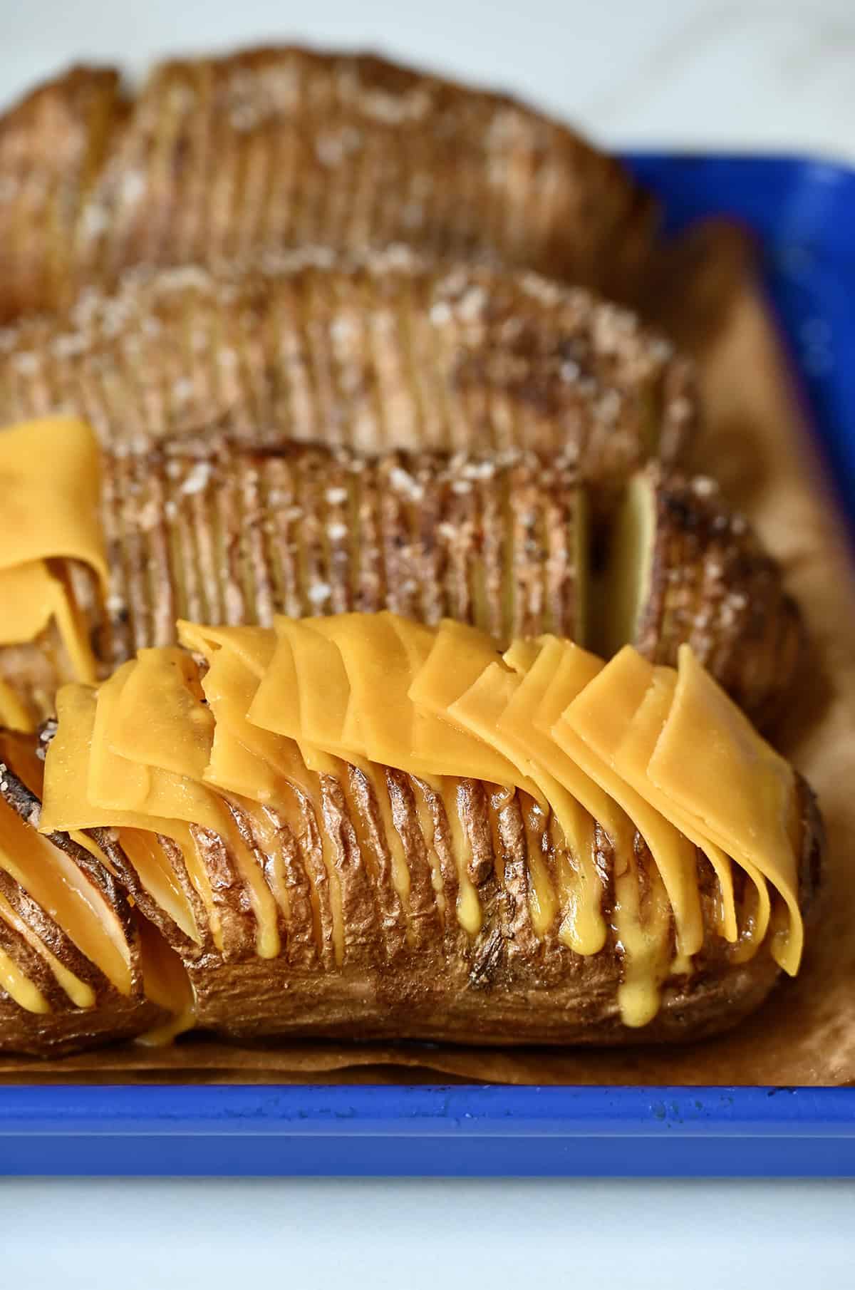 Cheesy hasselback potatoes with cheddar cheese.