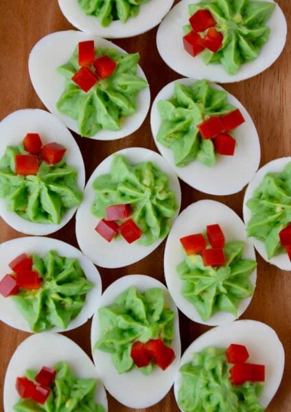 A wooden platter filled with Christmas Deviled Eggs