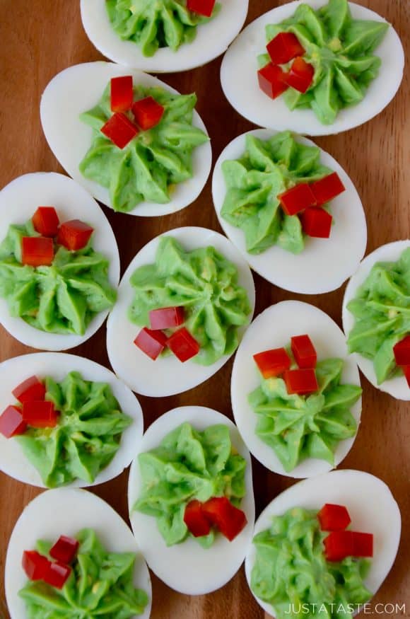 A wooden platter filled with Christmas Deviled Eggs