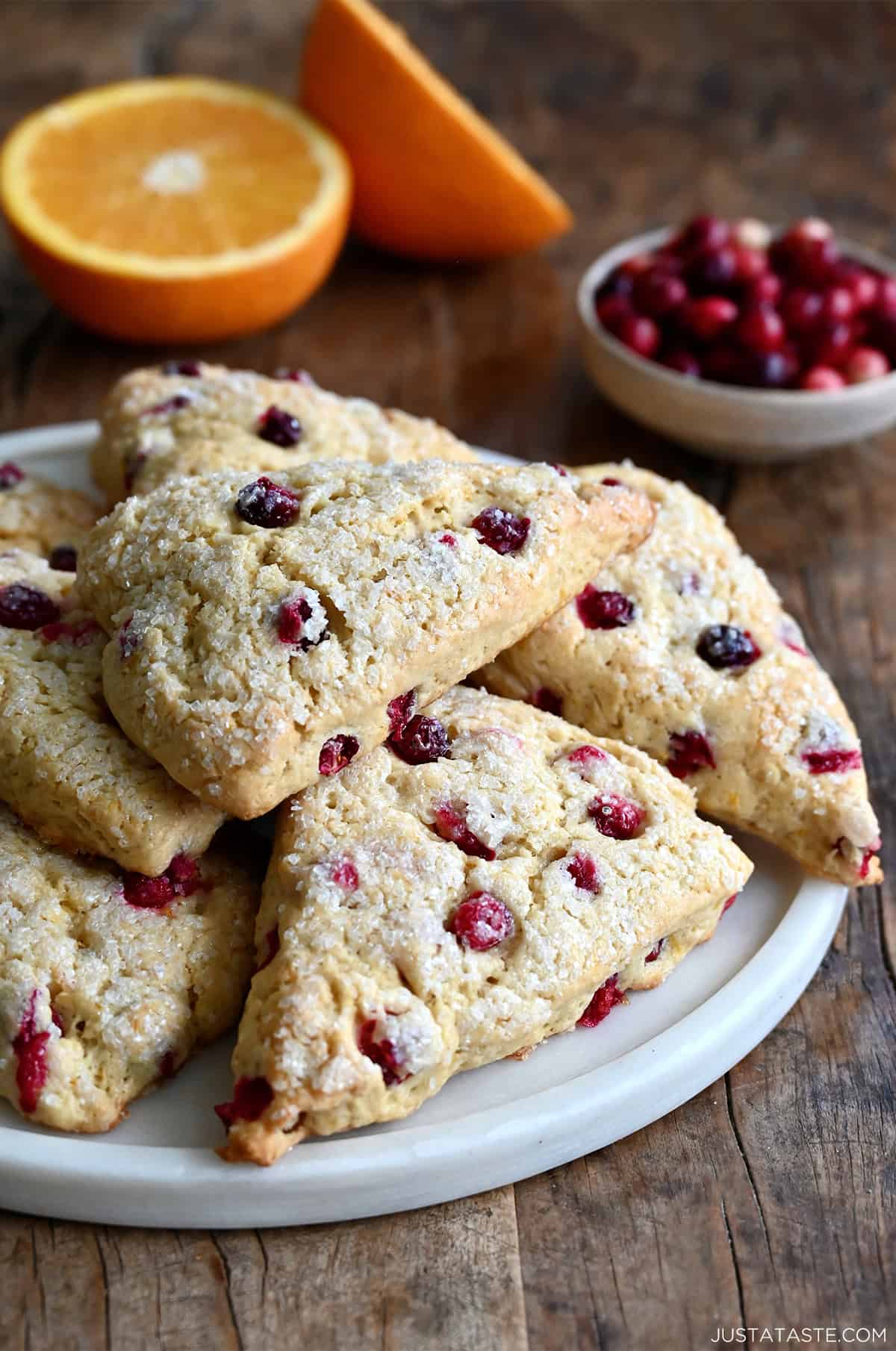 Cranberry orange scones with a sparkling coarse sugar topping piled on a serving platter.