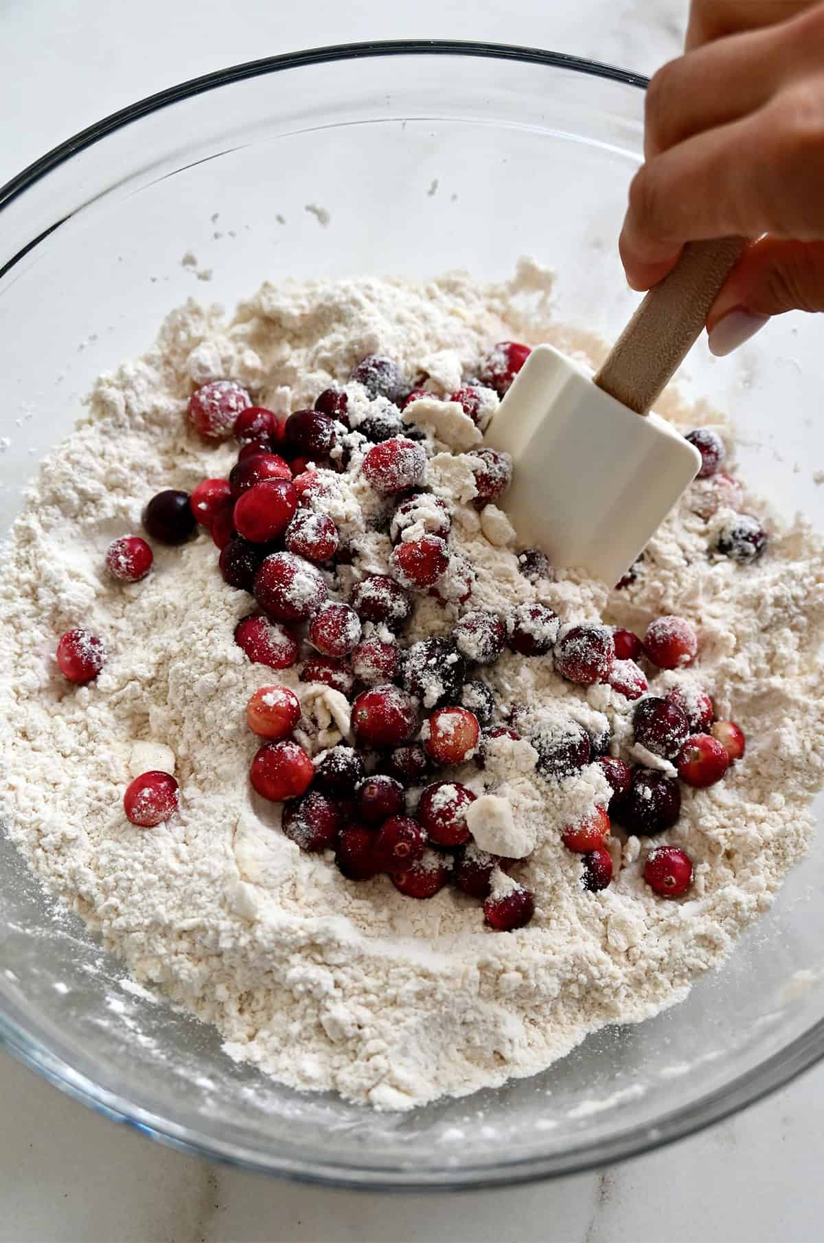 Folding cranberries into a flour and butter mixture.