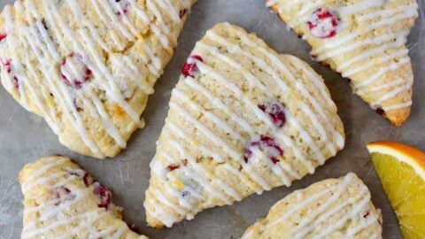 Glazed Orange Cranberry Scones with orange slices on gray background