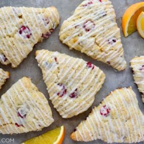 Orange Cranberry Scones on gray background with orange slices