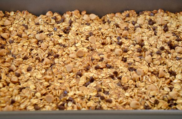 Nonstick baking pan with even layer of Homemade Peanut Butter Granola Bars