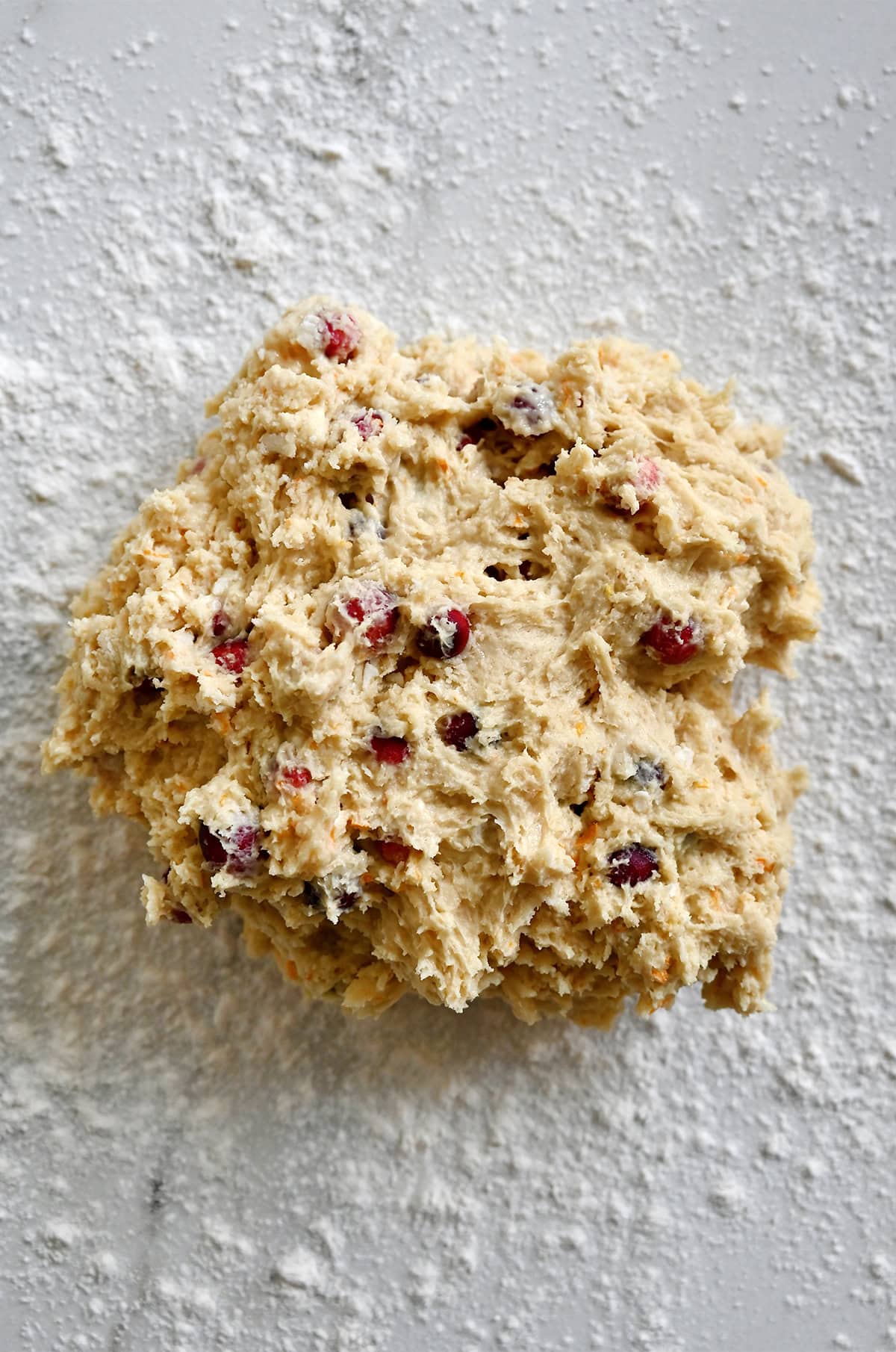 Shaping orange cranberry scone dough on a floured surface.