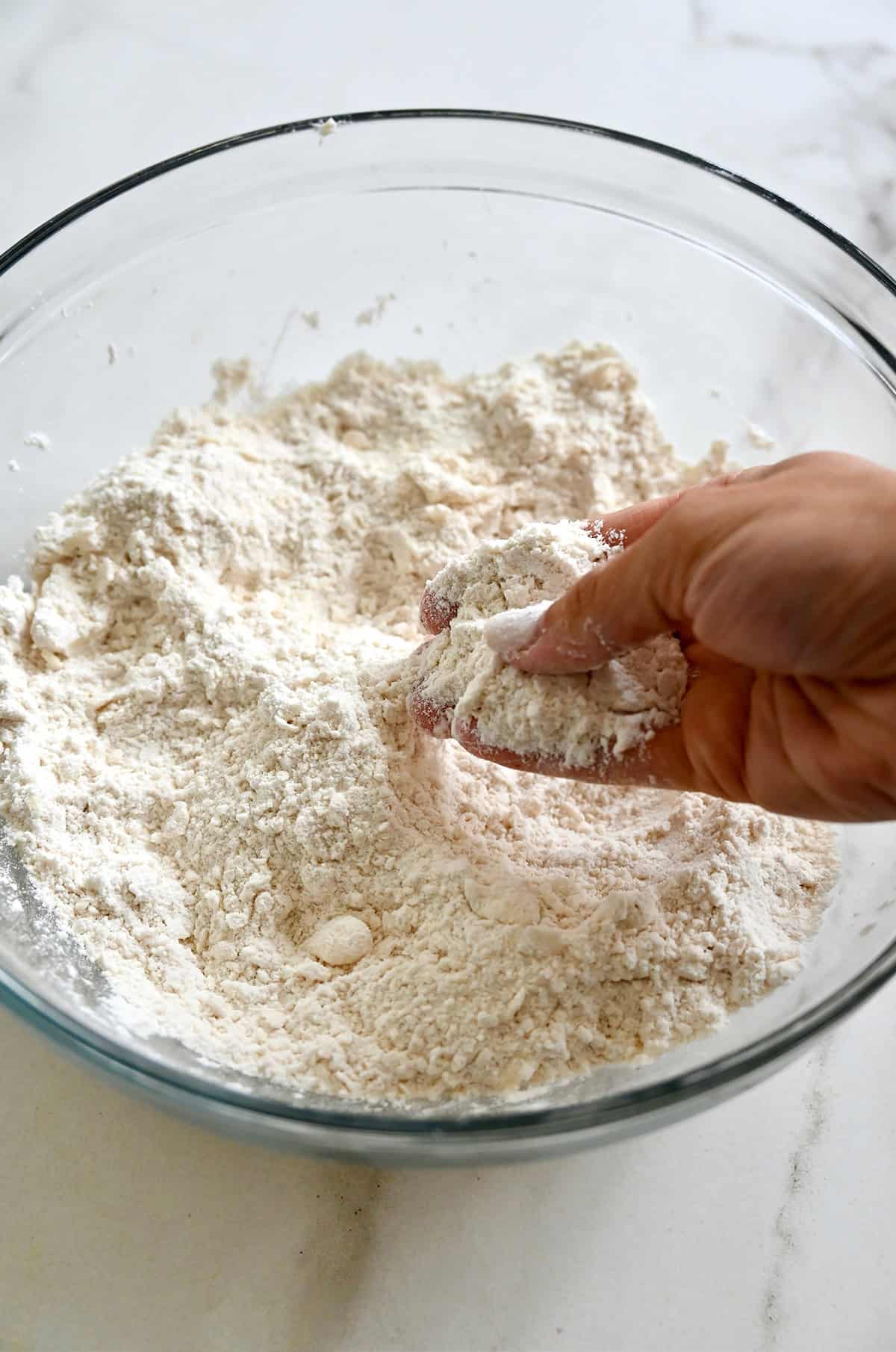 Cutting cold, cubed butter into flour.