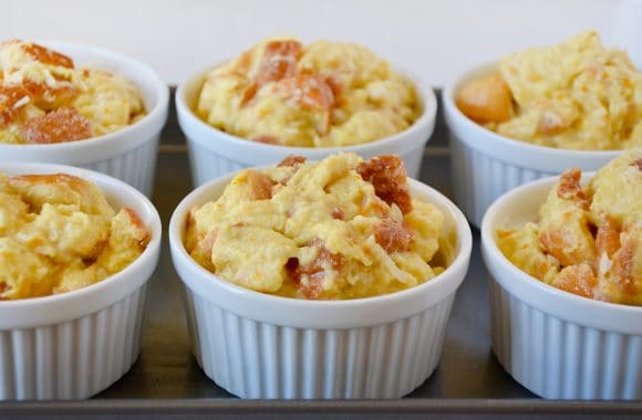 White ramekins filled with brioche bread pudding arranged on a metal baking sheet