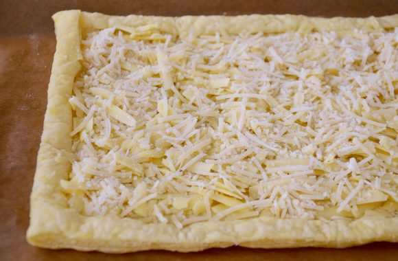 Puff pastry tart with shredded gruyere and Parmesan cheeses.