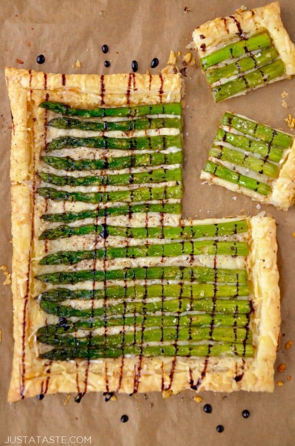 Cheesy Asparagus Tart drizzled with balsamic syrup on brown paper