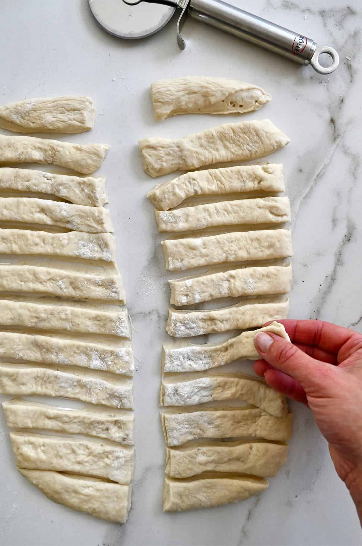 Strips of pizza dough to form garlic knots.