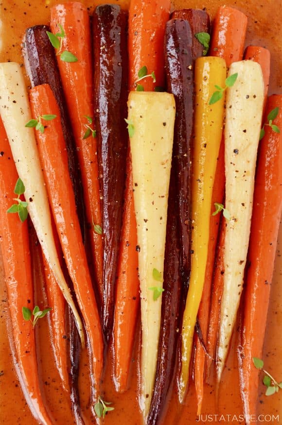 Multi-colored Easy Honey Roasted Carrots on cutting board.