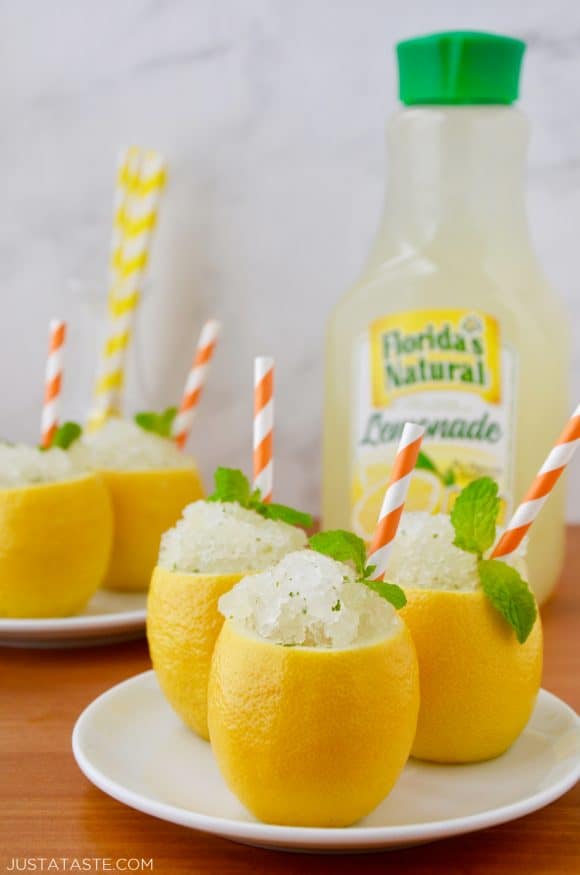 Easy Lemon Granita served in hollowed out lemons with mint leaves and orange striped straws